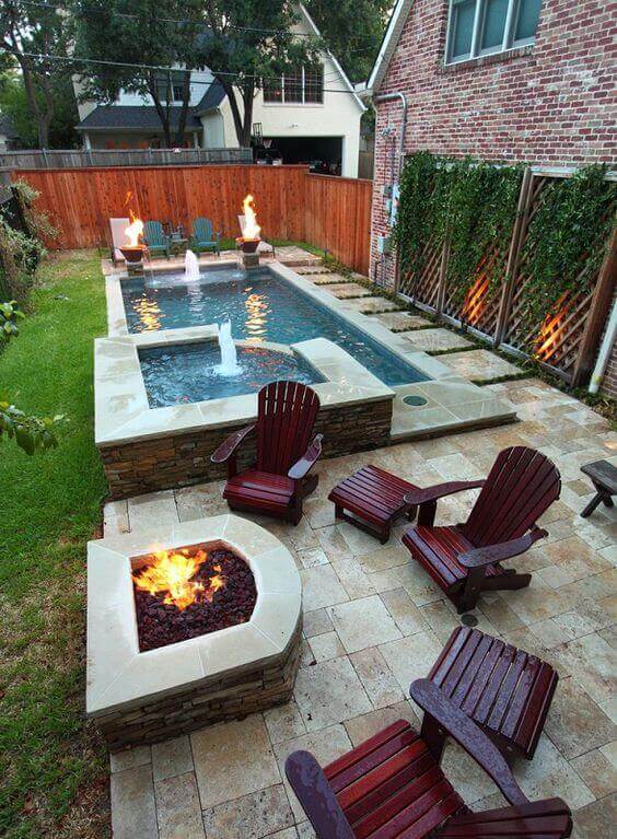 Cozy backyard featuring a rectangular fire pit with masonry, surrounded by Adirondack chairs and a patio of large tiles, enhancing social interaction.