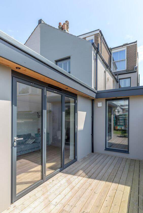 Contemporary patio door ideas showcase glass sliding doors leading to a wooden deck, enhancing indoor-outdoor flow and urban aesthetics.