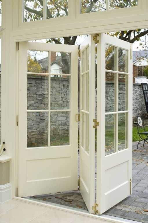 Double French doors with multiple glass panes in a neutral cream tone, providing a stylish transition from indoor to outdoor spaces.