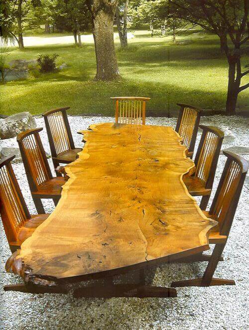 Handcrafted live edge dining table made from a single wood slab, 8 feet long, seating eight, with a rustic finish for outdoor settings.