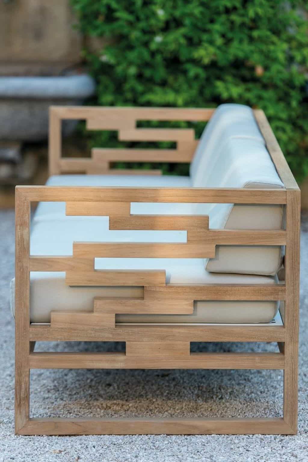Modern loveseat with geometric design, wooden frame, and plush white upholstery, ideal for outdoor settings. Weather-resistant materials.