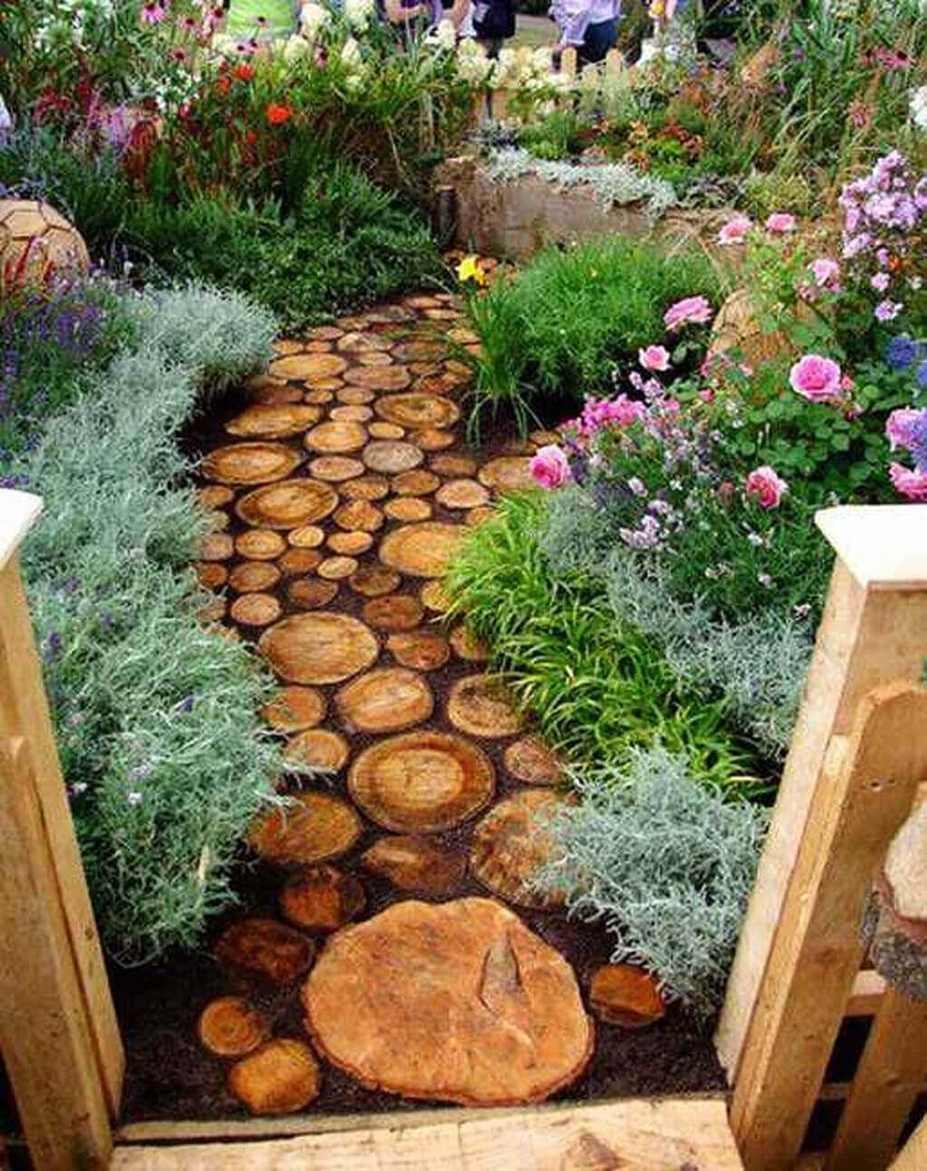 Pathway of circular timber discs, 30-50 cm in diameter, surrounded by lush flowering plants and aromatic herbs, enhancing curb appeal and biodiversity.
