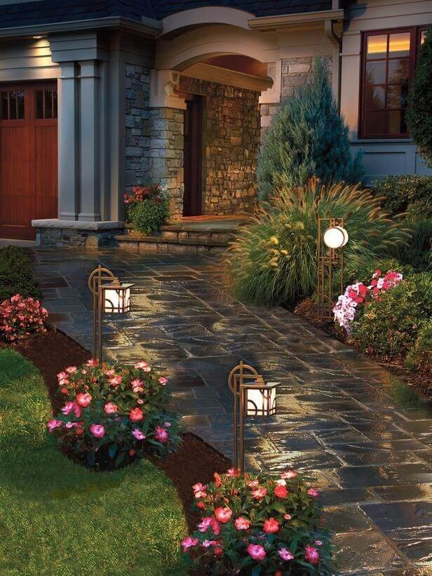Well-designed pathway with a slate stone finish, bordered by vibrant pink Impatiens in rich brown mulch, enhancing curb appeal.