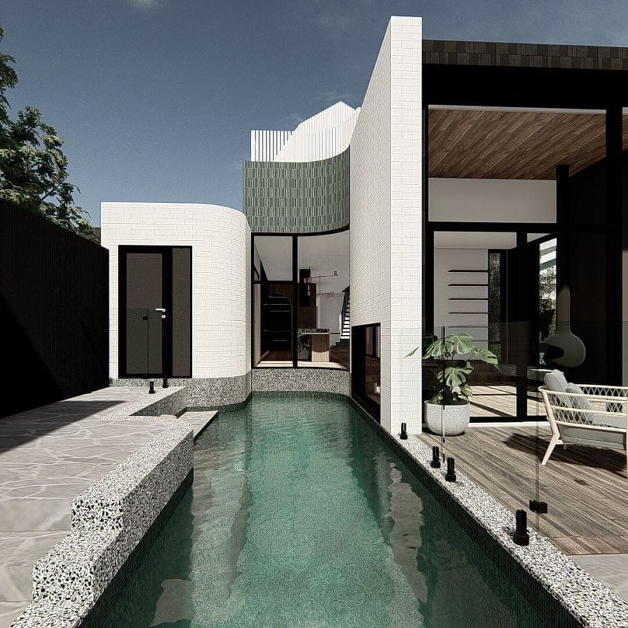 Sleek curved swimming pool in a modern backyard, surrounded by a stone patio and lush greenery, perfect for relaxation and entertaining.