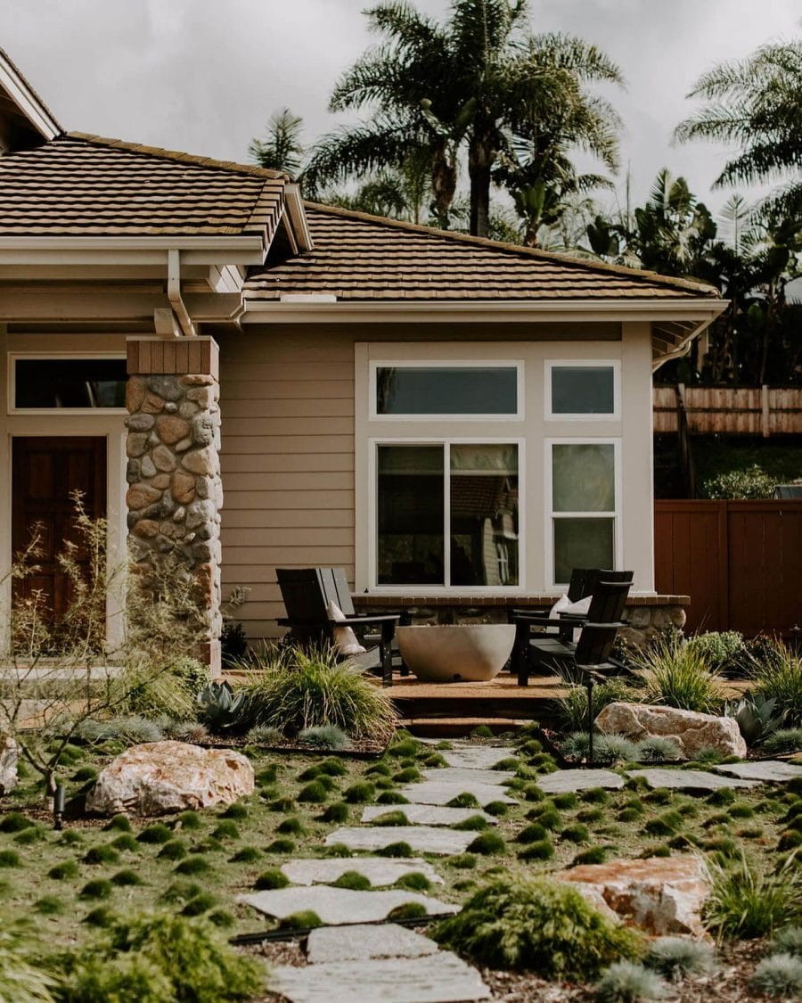 Landscaped garden with a stone pathway and seating area, featuring low-maintenance plants and a fire bowl, ideal for budget-friendly outdoor living.